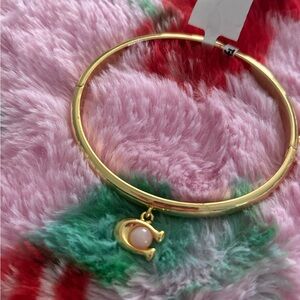 New coach bangle. Beautiful gold coach bangle with pink pearl charm